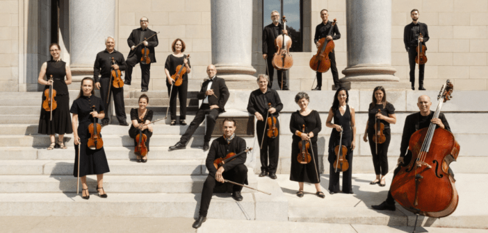 I Musici de Montréal - Chamber Orchestra standing on beige stairs